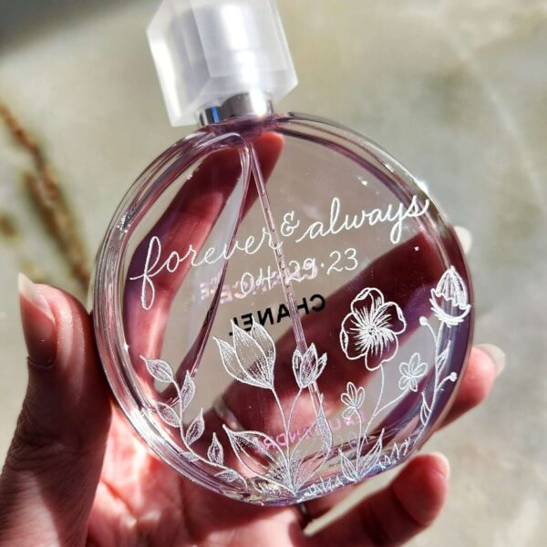 Round perfume bottle hand engraved with florals and the phrase "always & forever" in calligraphy with the wedding date underneath